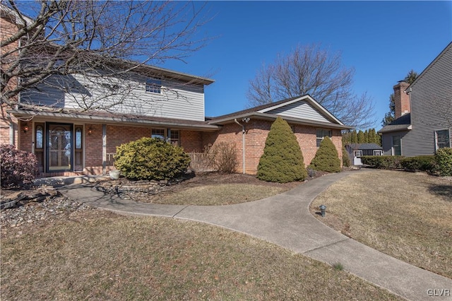 traditional home with a front yard and brick siding