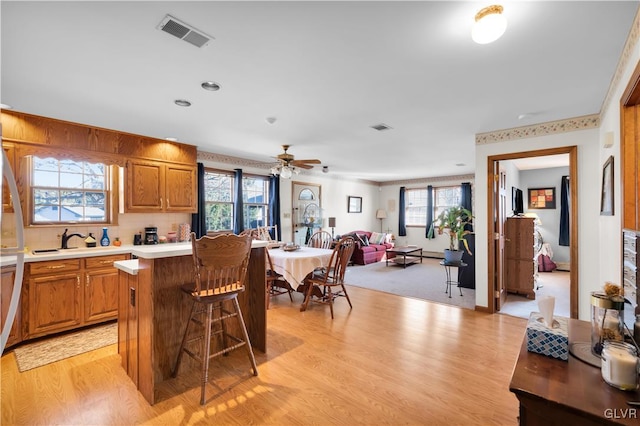 kitchen with light wood-type flooring, visible vents, light countertops, and open floor plan