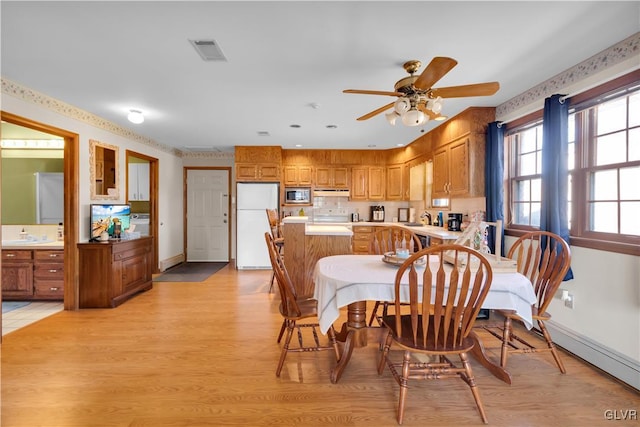 dining space with ceiling fan, light wood-style flooring, visible vents, and baseboards