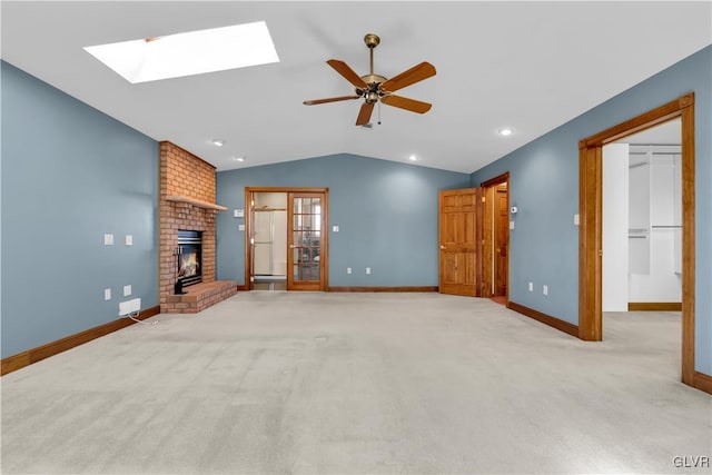 unfurnished living room featuring carpet floors, a ceiling fan, a brick fireplace, vaulted ceiling, and baseboards