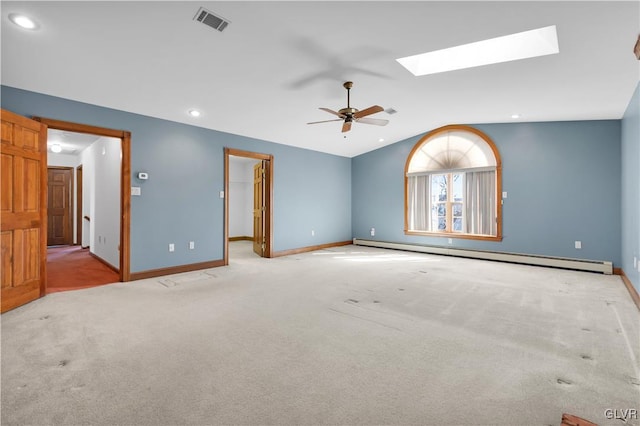 spare room with vaulted ceiling with skylight, visible vents, baseboards, carpet, and baseboard heating