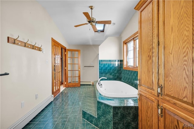 bathroom featuring a baseboard radiator, vaulted ceiling, tile patterned flooring, a jetted tub, and baseboards