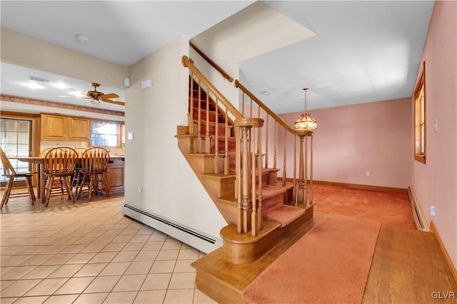 stairway with a ceiling fan, tile patterned flooring, baseboards, and baseboard heating