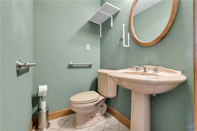 bathroom with tile patterned flooring, baseboards, and toilet