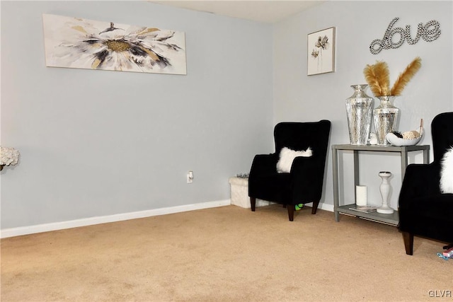 living area with baseboards and light colored carpet