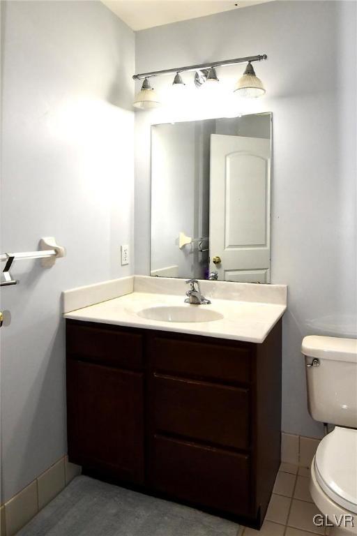 bathroom featuring vanity, toilet, and tile patterned floors