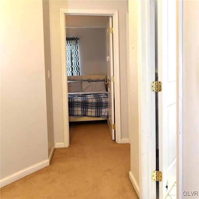 hallway with carpet flooring and baseboards