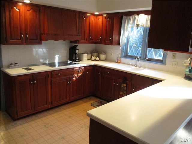 kitchen with light floors, decorative backsplash, black electric cooktop, and light countertops