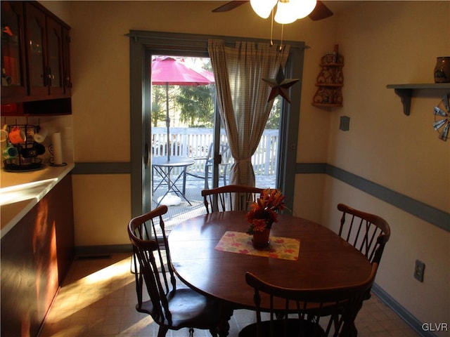 dining space with light floors, ceiling fan, and baseboards