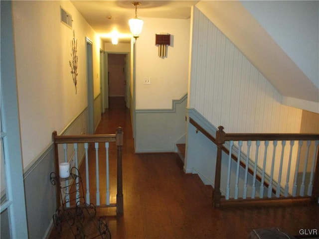 hall featuring visible vents, an upstairs landing, and wood finished floors