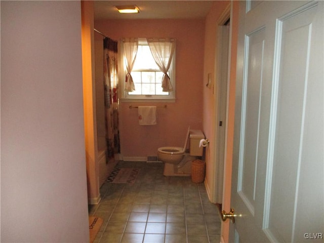 full bathroom with toilet, curtained shower, and tile patterned floors