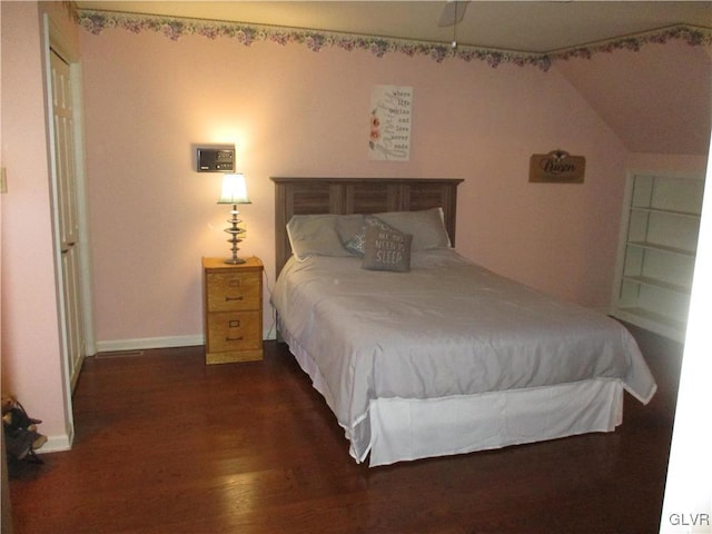 bedroom featuring lofted ceiling, baseboards, and wood finished floors