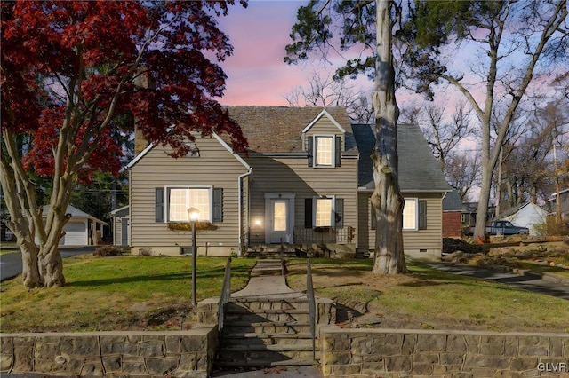 cape cod home with a shingled roof, crawl space, and a front lawn