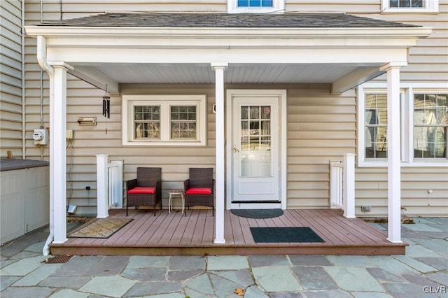 view of exterior entry featuring a shingled roof