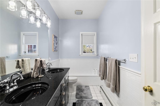 full bathroom featuring a wainscoted wall, a sink, and visible vents