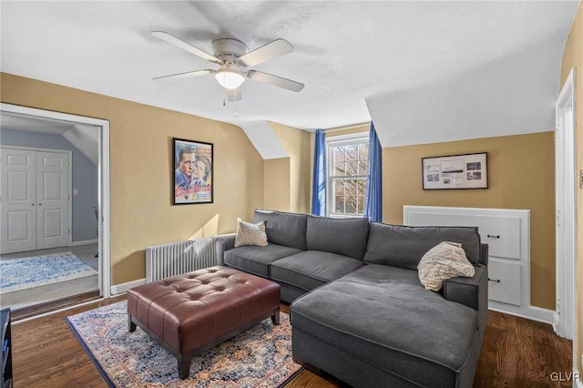 living area with lofted ceiling, wood finished floors, a ceiling fan, and baseboards