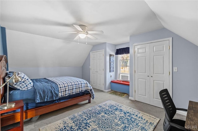 bedroom with lofted ceiling, baseboards, and two closets