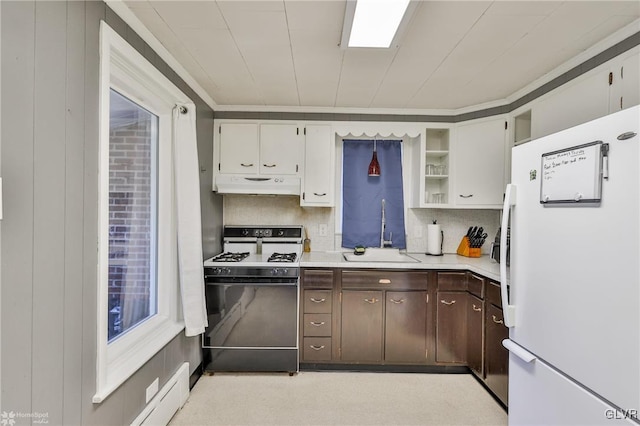 kitchen featuring range with gas cooktop, light countertops, freestanding refrigerator, a sink, and under cabinet range hood