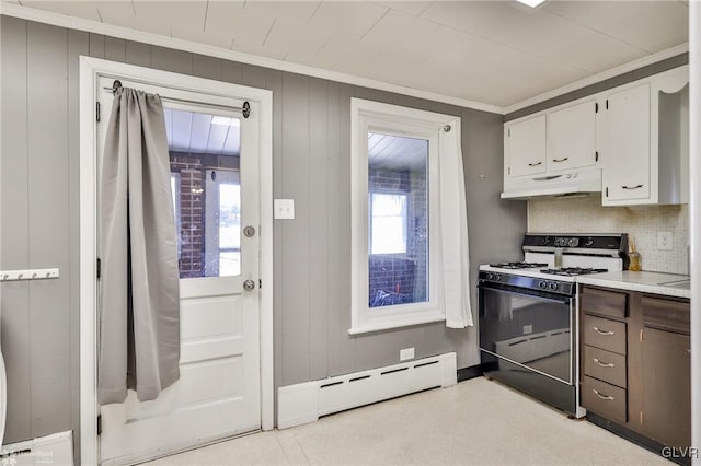 kitchen featuring range with gas cooktop, a wealth of natural light, baseboard heating, white cabinets, and under cabinet range hood