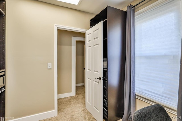 interior space with light carpet and baseboards