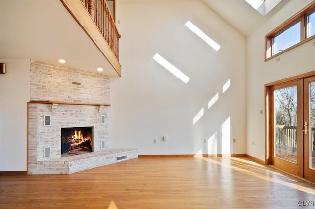 unfurnished living room featuring french doors, a high ceiling, wood finished floors, and visible vents