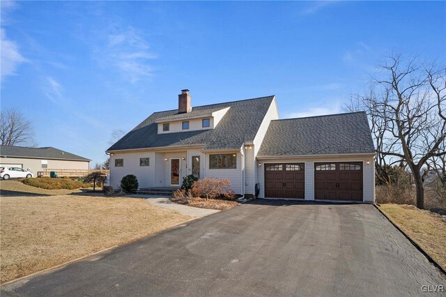 view of front of property featuring a garage, roof with shingles, aphalt driveway, and a chimney