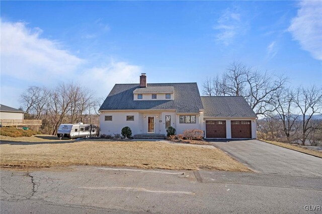 view of front of home with aphalt driveway, a shingled roof, a chimney, and a garage