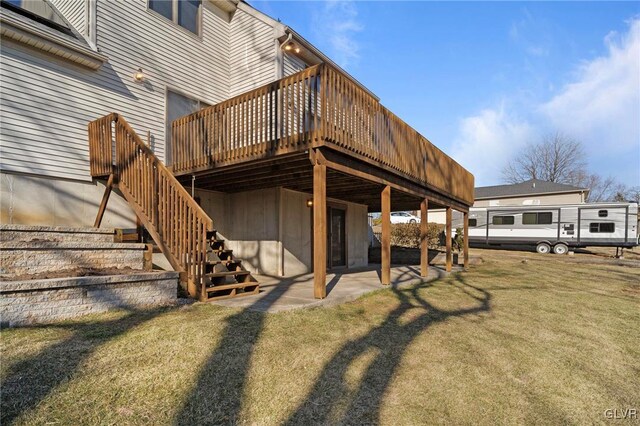 rear view of property with a deck, a lawn, stairway, and a patio