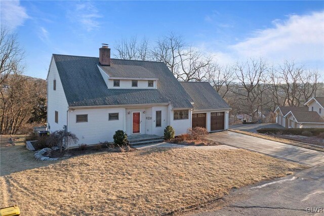 view of front of home featuring an attached garage, driveway, a chimney, and roof with shingles