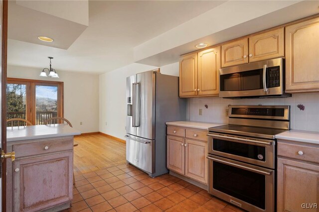 kitchen featuring stainless steel appliances, backsplash, and light brown cabinets