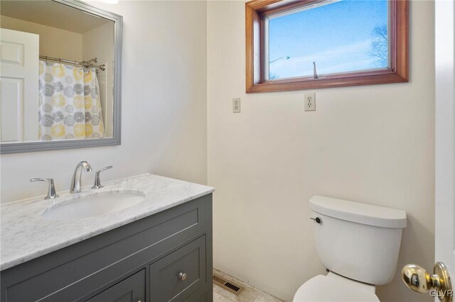 bathroom featuring visible vents, vanity, and toilet