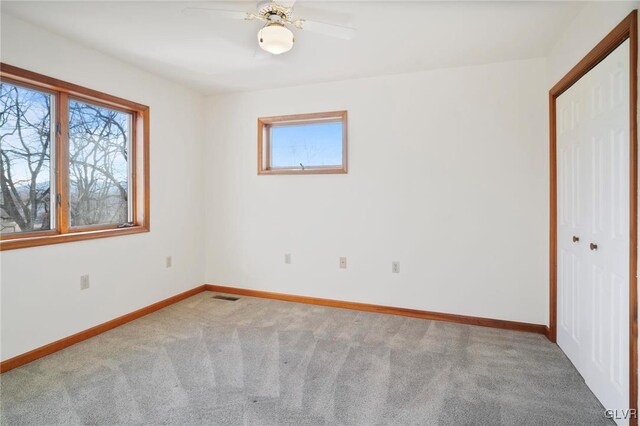 unfurnished bedroom featuring baseboards, visible vents, ceiling fan, carpet flooring, and a closet