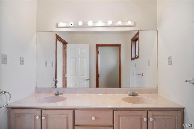 full bathroom with double vanity and a sink