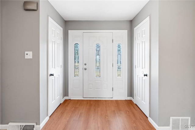 foyer featuring light wood-style floors, baseboards, and visible vents