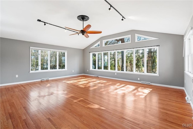 empty room with lofted ceiling, visible vents, and wood finished floors