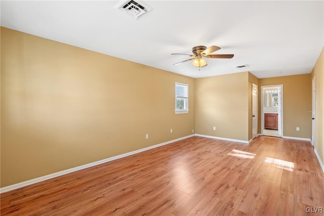 spare room with light wood finished floors, baseboards, and visible vents