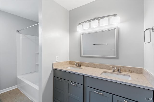 bathroom featuring double vanity, shower / washtub combination, a sink, and baseboards