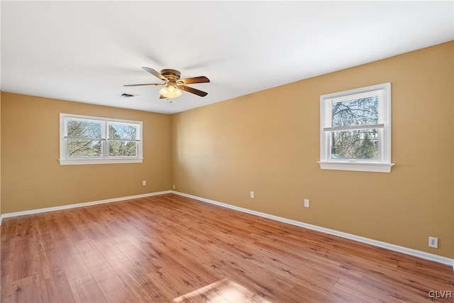 unfurnished room featuring light wood-type flooring, a ceiling fan, and baseboards