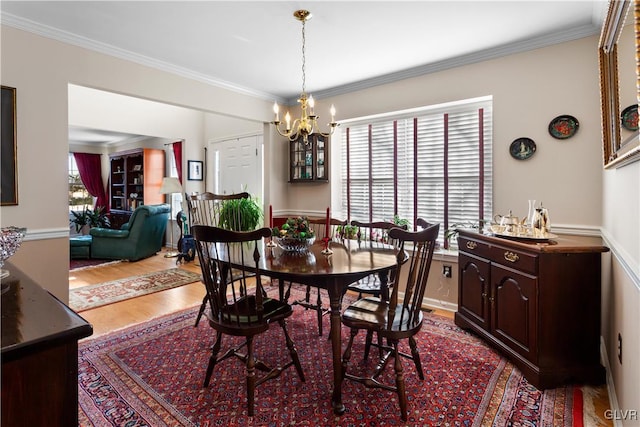 dining room featuring a chandelier, crown molding, and wood finished floors