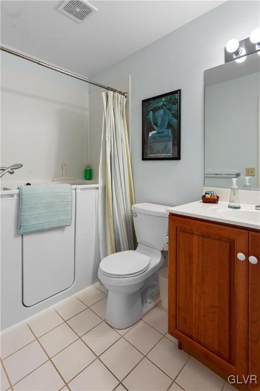 bathroom with visible vents, a shower with shower curtain, toilet, vanity, and tile patterned flooring