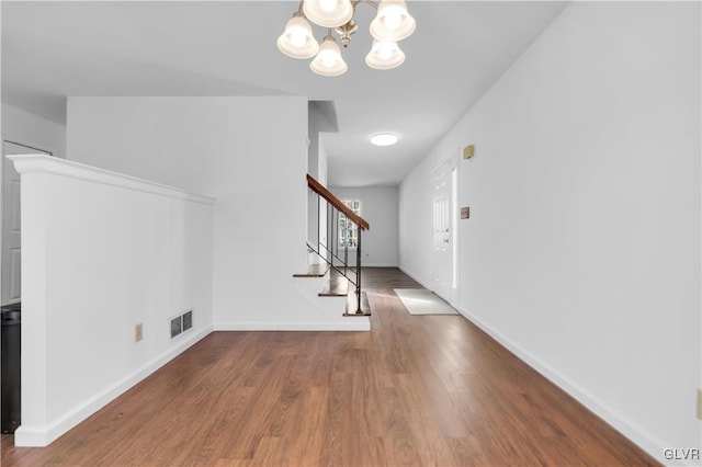 entryway featuring visible vents, stairway, baseboards, and wood finished floors