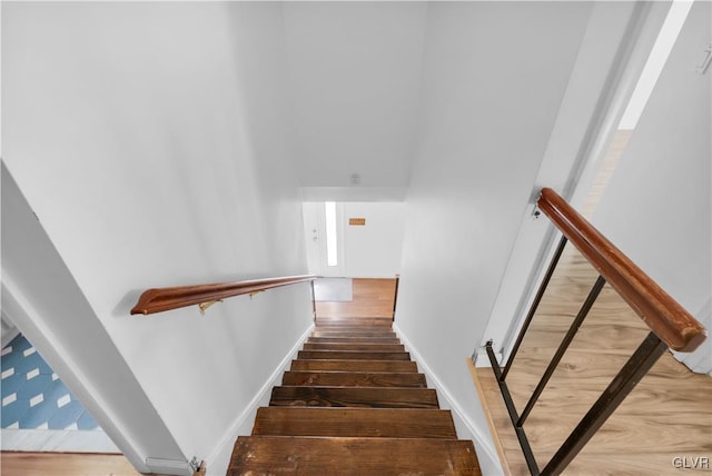 stairway featuring baseboards and wood finished floors