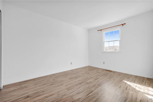 empty room with visible vents and wood finished floors