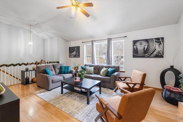 living area featuring light wood-style floors, ceiling fan, baseboards, and vaulted ceiling