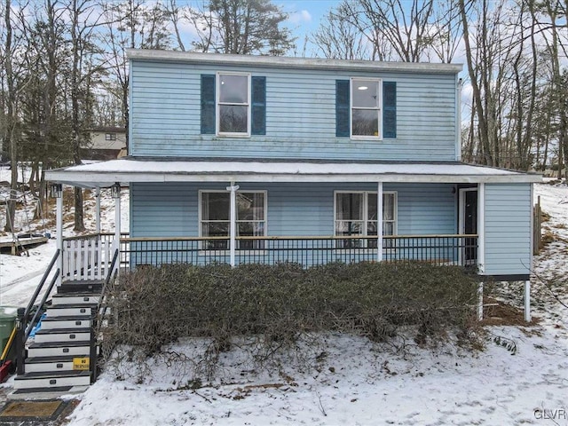 view of front of home featuring covered porch and stairs