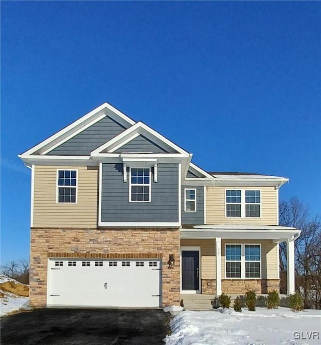 view of front of house featuring stone siding, driveway, and an attached garage