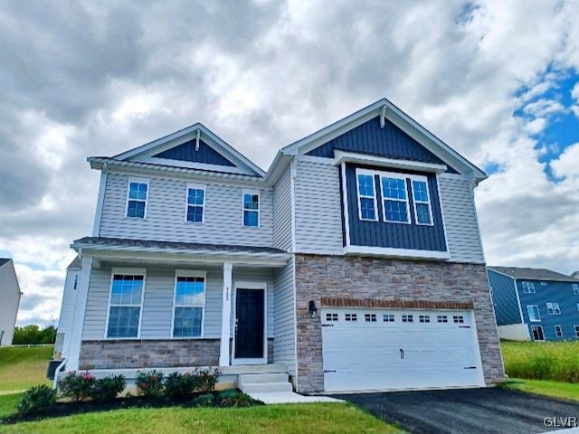 craftsman inspired home featuring a garage, entry steps, stone siding, and driveway