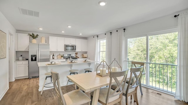 dining space featuring light wood-style floors, recessed lighting, and visible vents