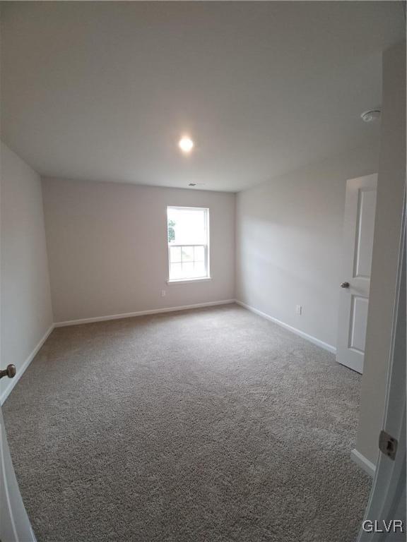 empty room with carpet floors and baseboards