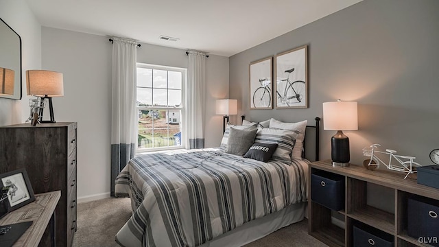 carpeted bedroom featuring baseboards and visible vents